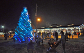 family by the lighted mayor's tree outside at Haymarket Square